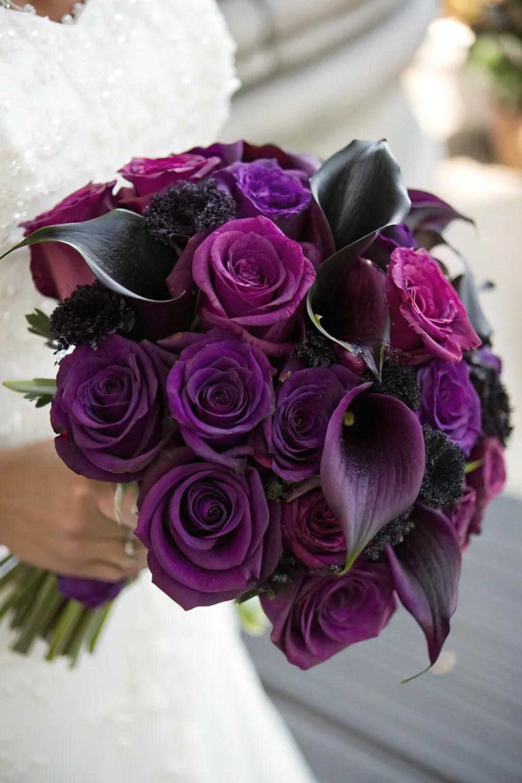 A breathtaking bouquet of deep purple roses and black calla lilies.