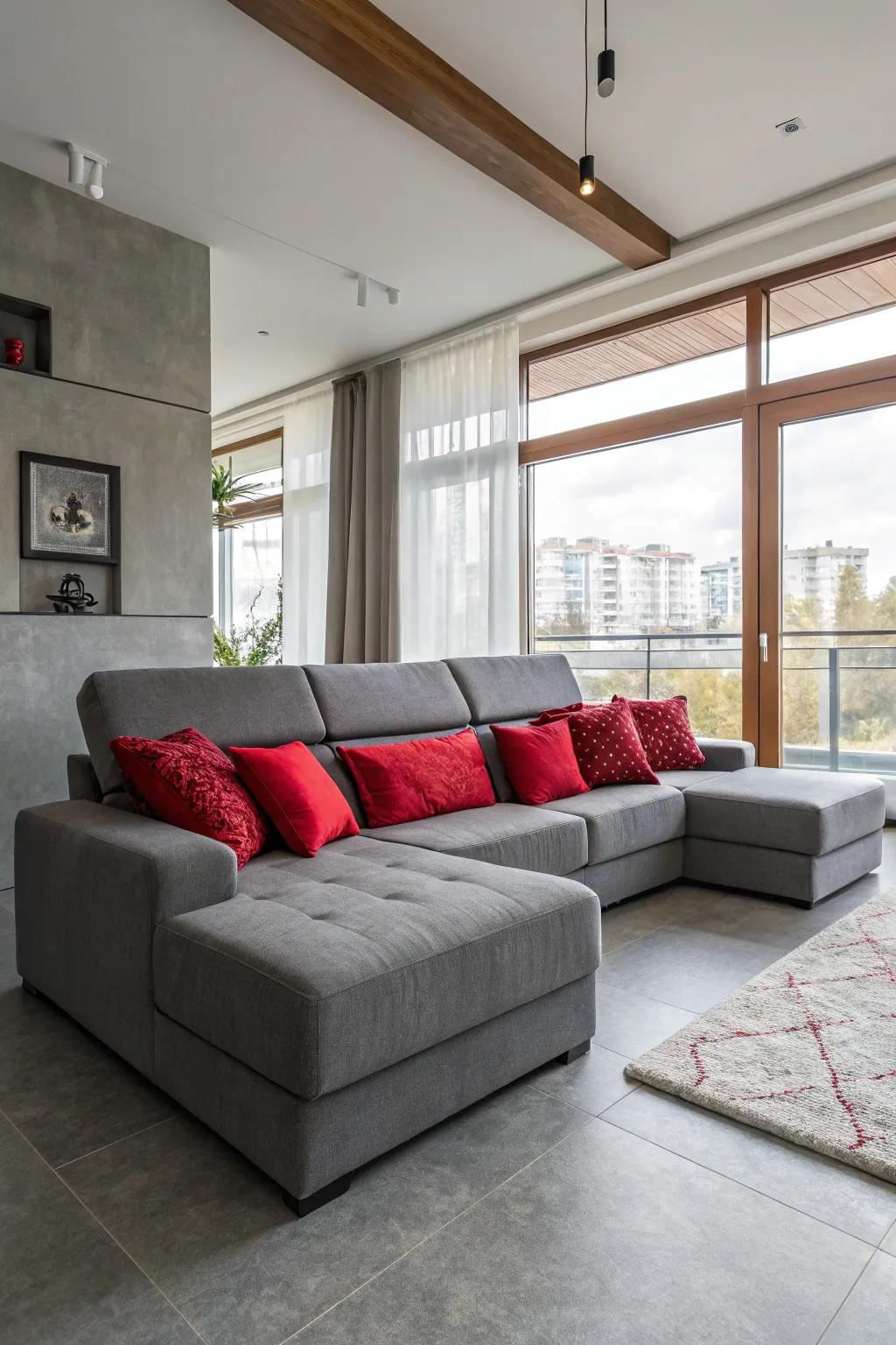 A cozy living room showcasing a grey sectional and red cushions.