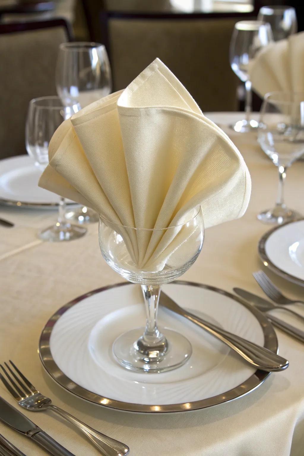 A silken cloth gently arranged into a time-honored fan, bringing class to the table.
