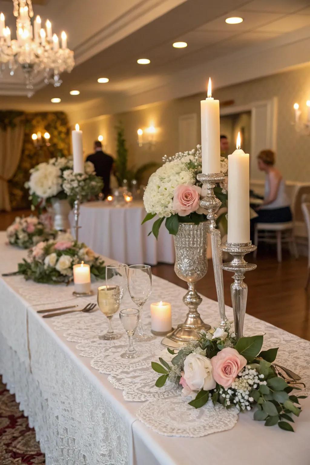 A bride and groom table featuring vintage candle holders and lace doilies.