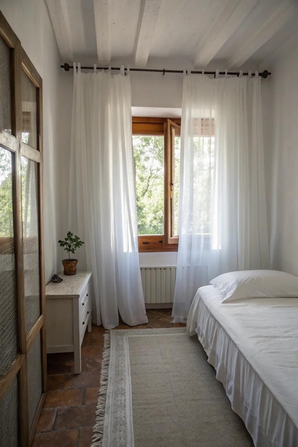 Pale drapes help make this compact bedroom feel more expansive.