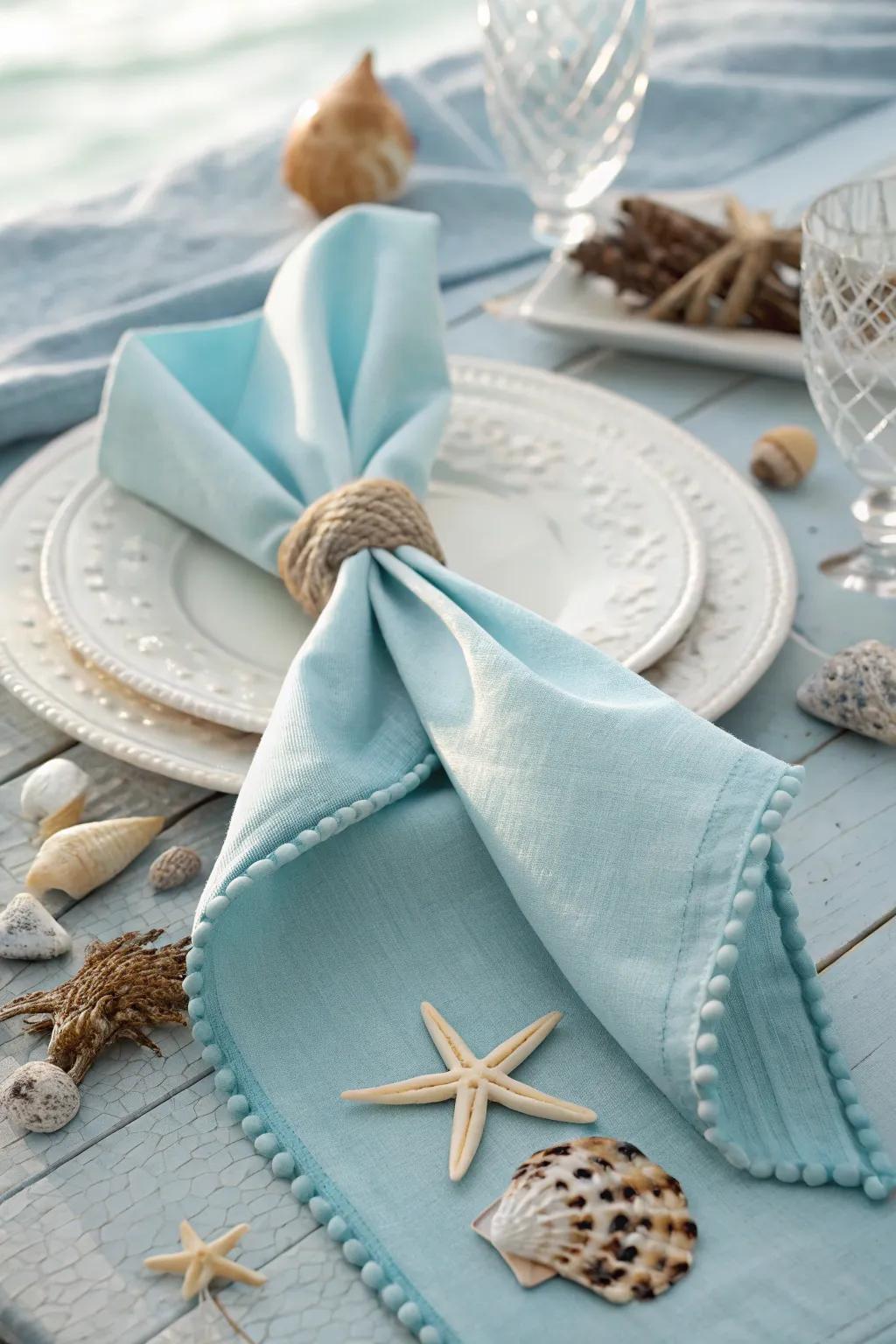 A silken cloth arranged into a sea tail, great for giving a sea vibe to your table setting.