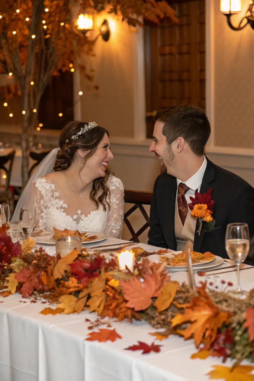 A bride and groom table adorned with seasonal decor like autumn leaves.