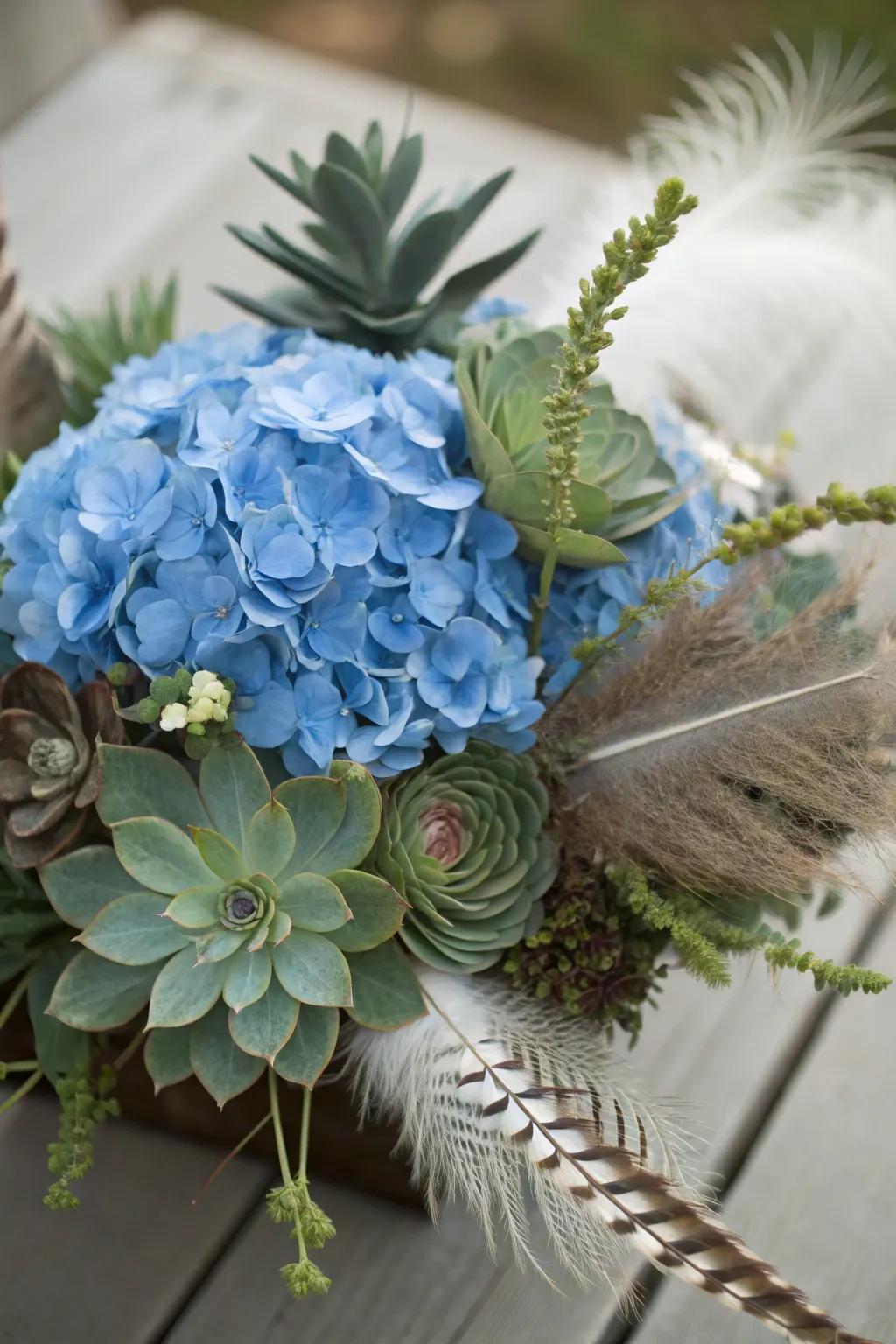 An eclectic centerpiece showcases azure hydrangeas, succulents, and feathers.