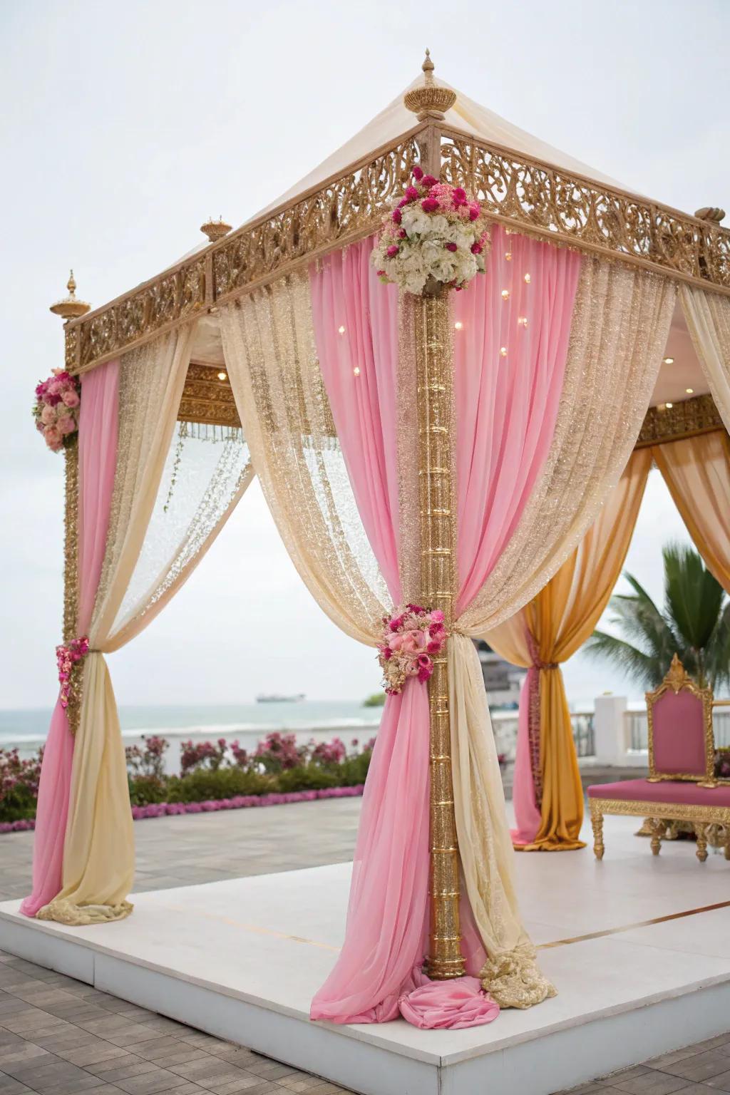 Luxurious flowing materials in gold and rose enveloping a mandap.