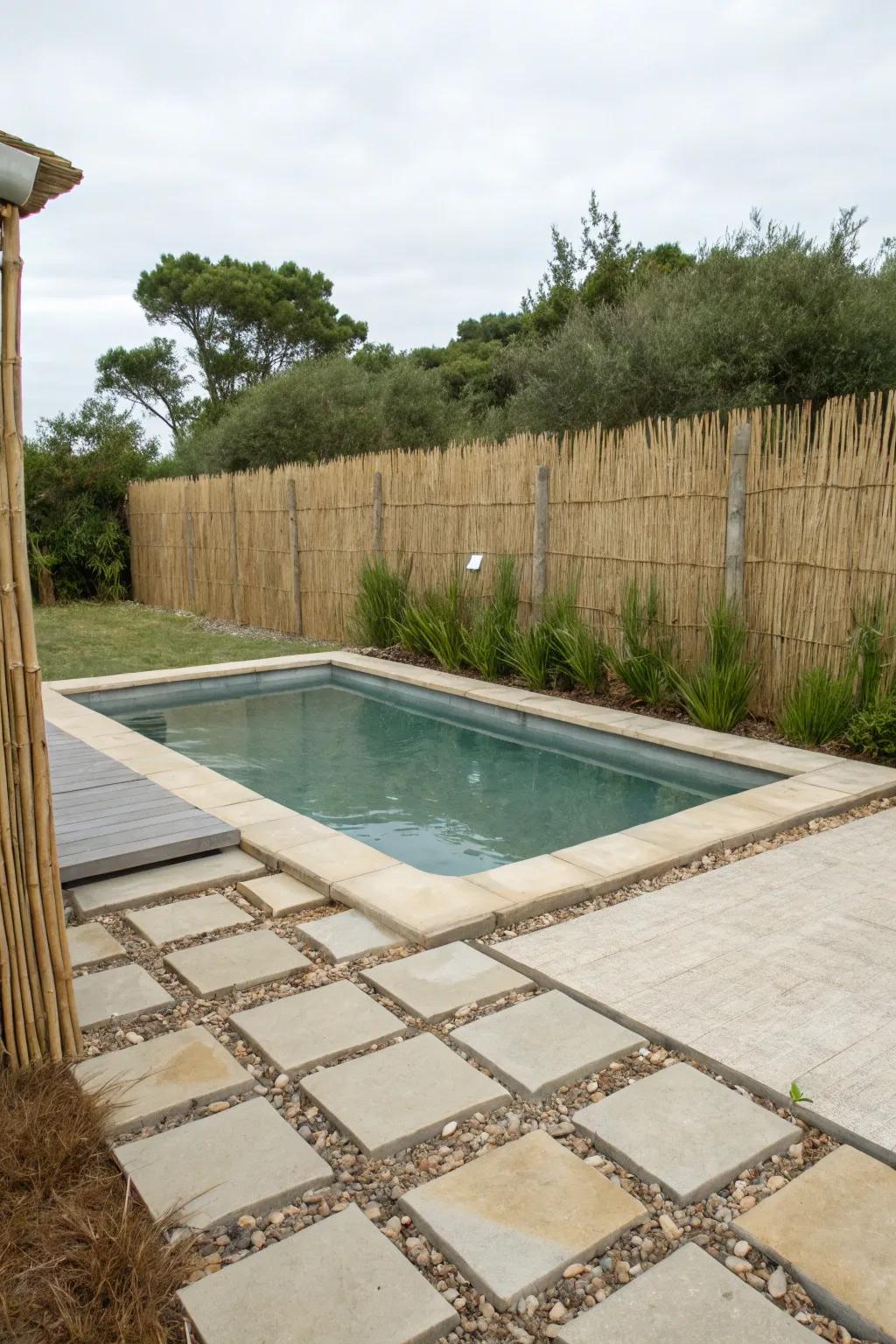 A reed fence creating a serene, beachy atmosphere by the pool.
