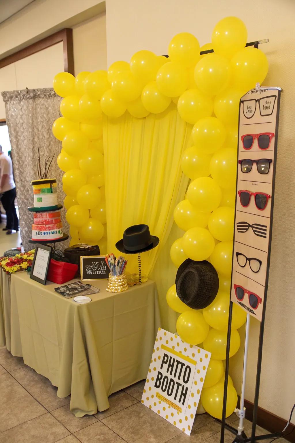 Photo booth featuring a fun yellow balloon backdrop.