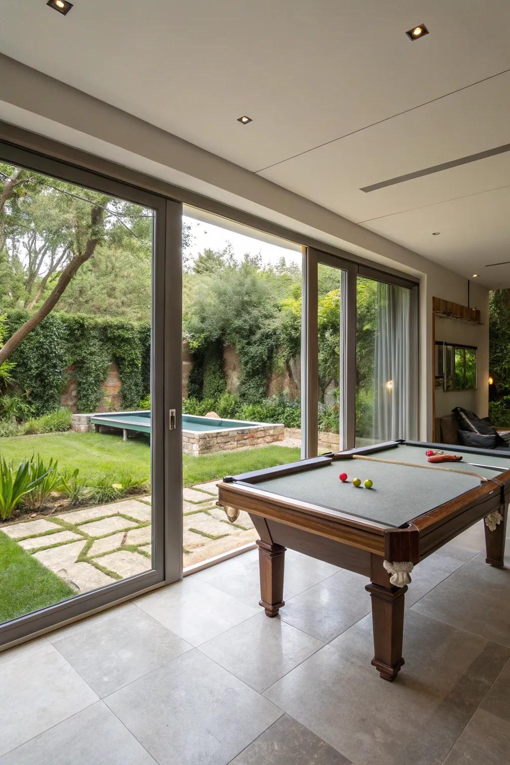 An indoor-outdoor living area that features a pool table and access to the garden.