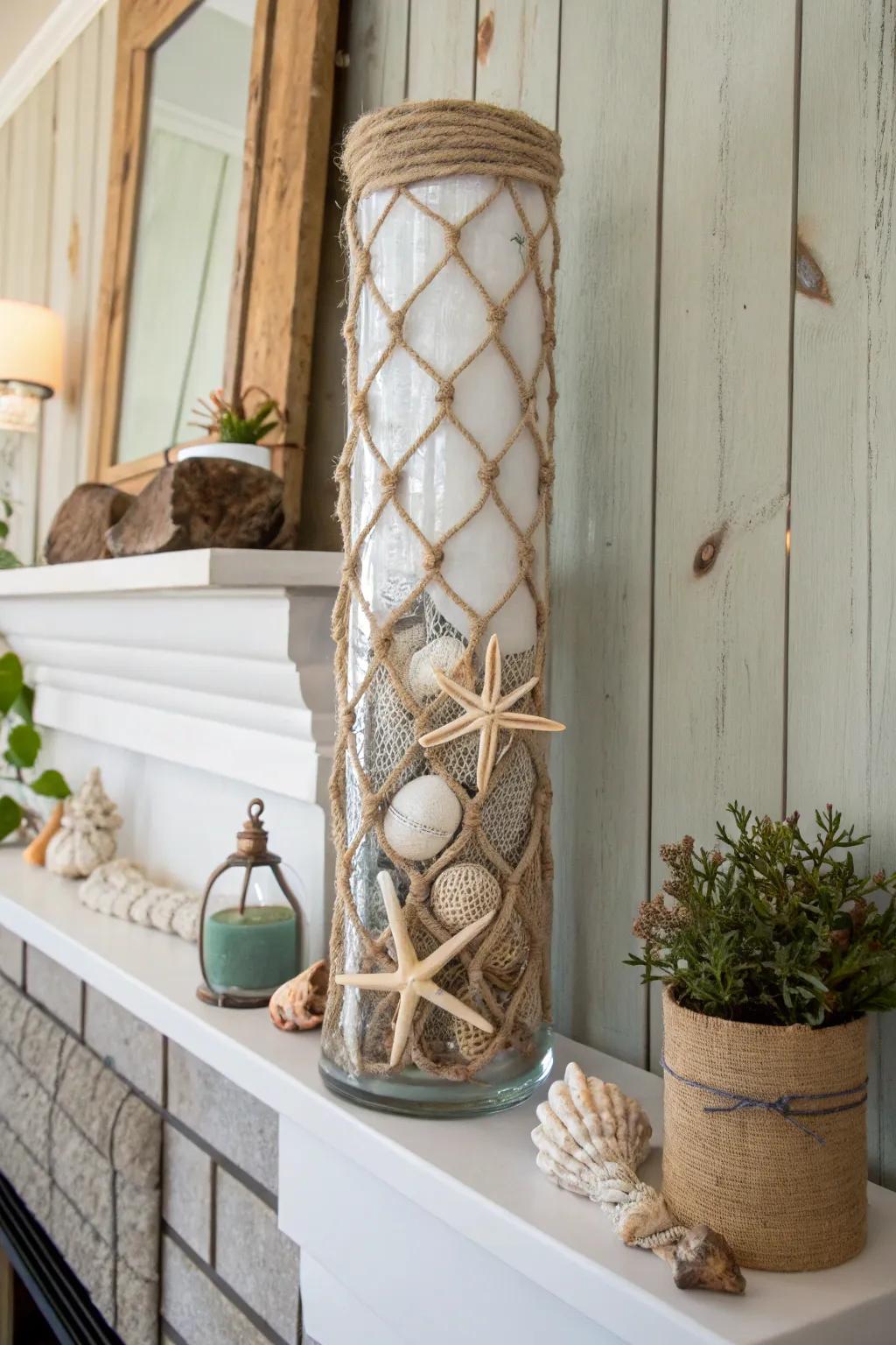 A nautical-themed tall glass vase wrapped with rope, adorned with seashells on a coastal mantle.