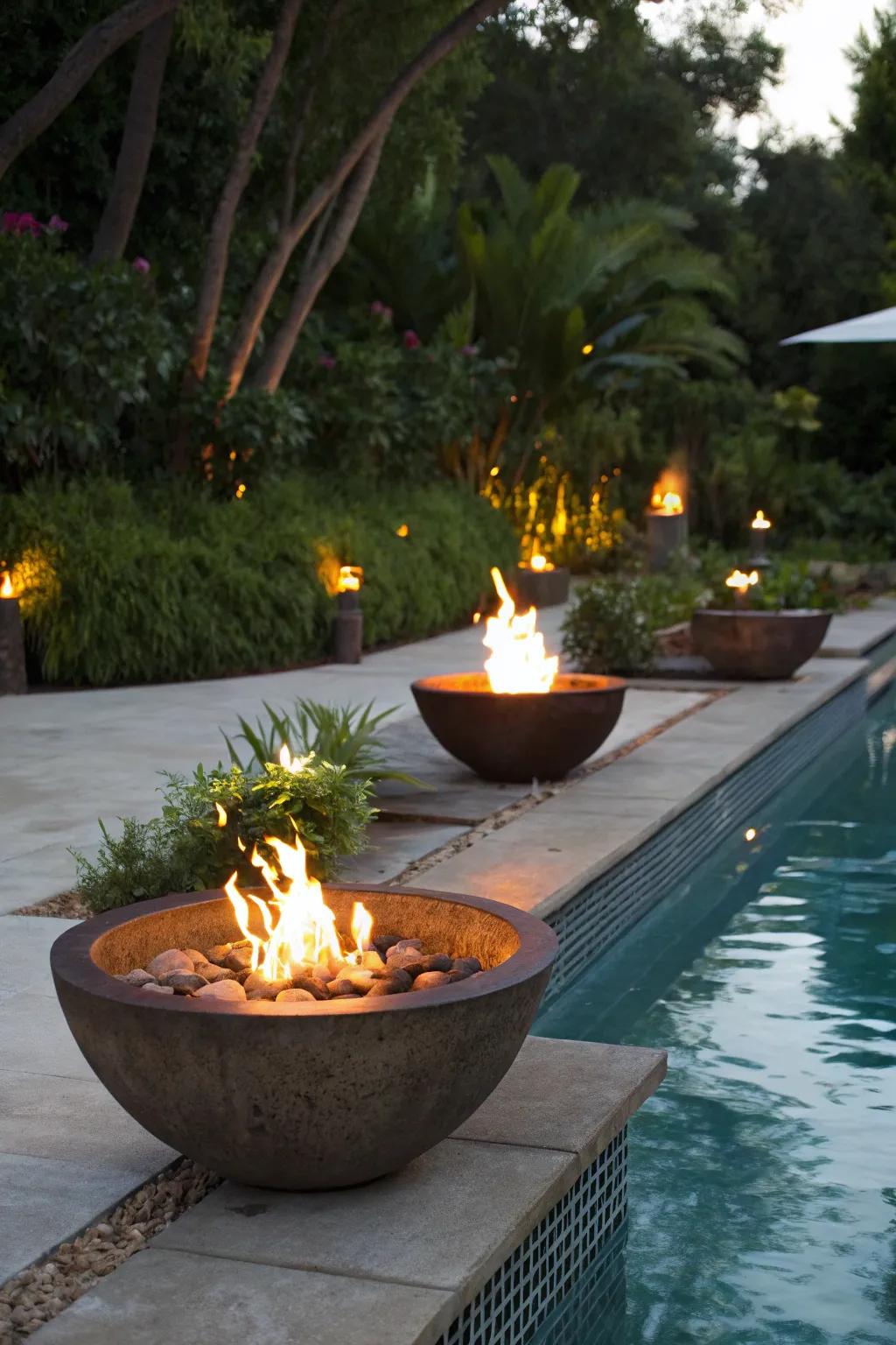 Fire bowls offer warmth and a striking visual around the pool.