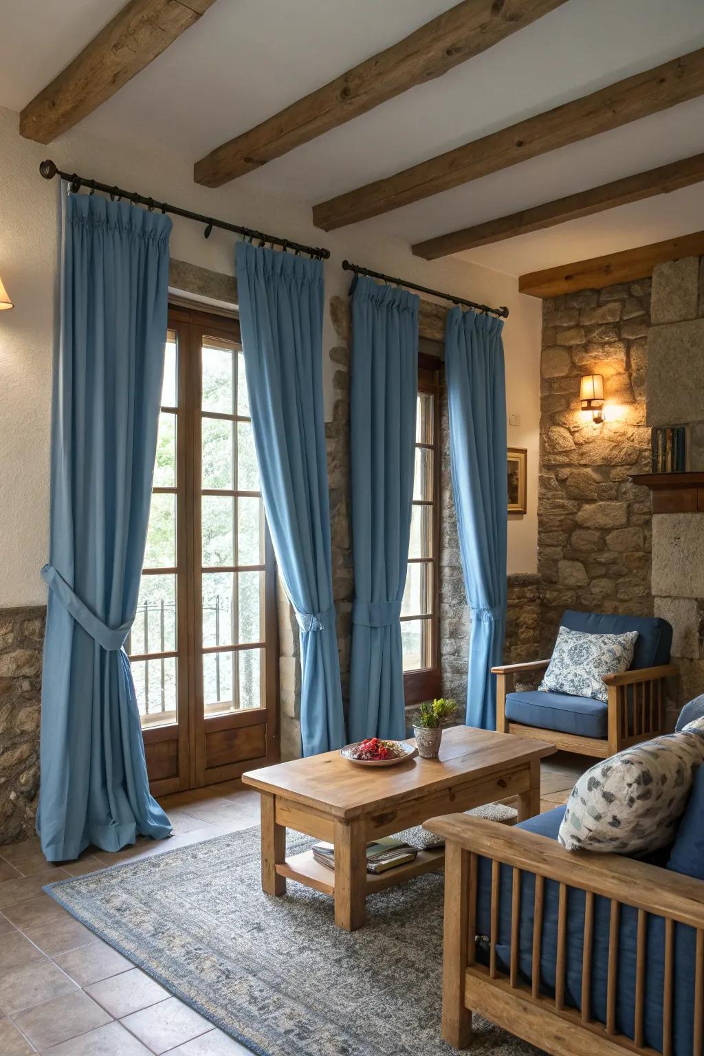 Natural components such as wood and rock supplement sky-tinted drapes, adding warmth and texture to the room.