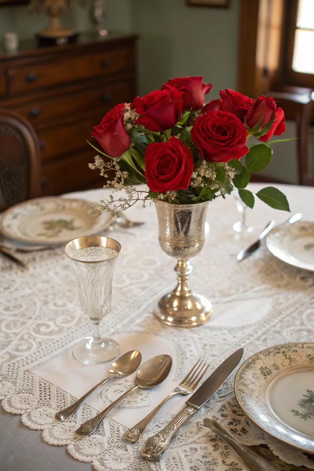 A classic centerpiece showcasing antique flatware and scarlet roses for traditional refinement.
