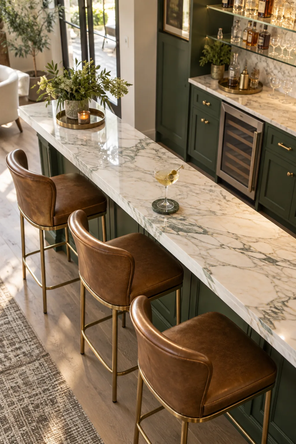 Close view of leather barstools tucked under a marble counter overhang with a green paneled base.