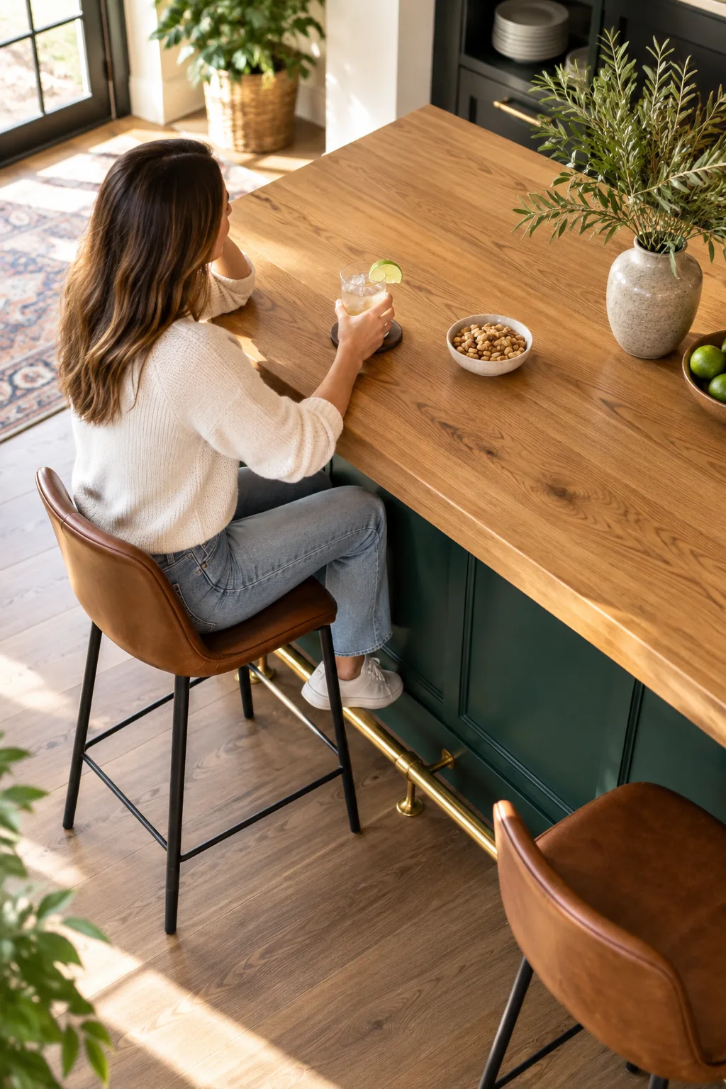 Side view of a person sitting at a home bar with their knees under the wood overhang.