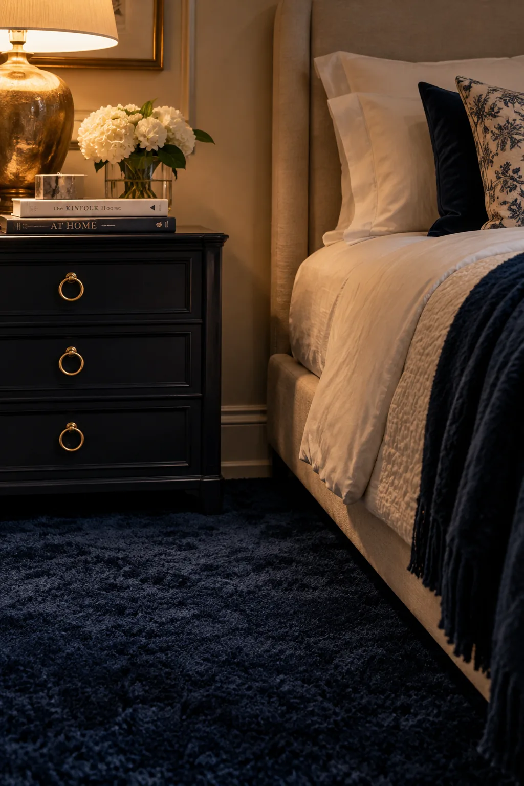 Navy blue bedroom carpet paired with sandy walls and brass accents