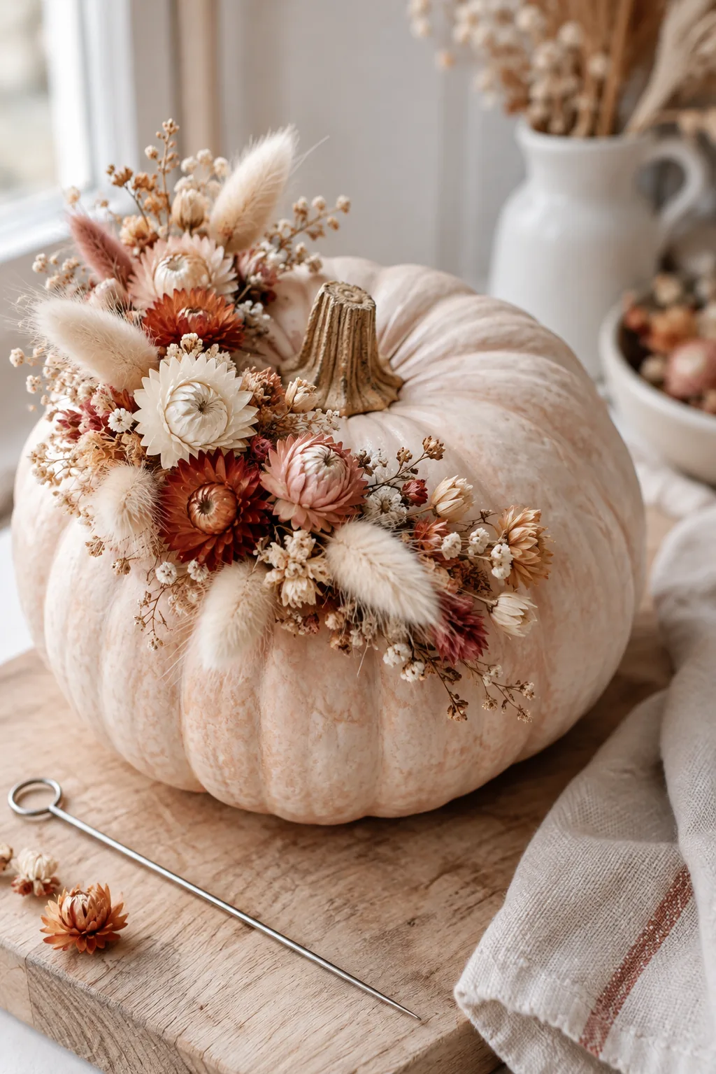 Cinderella pumpkin decorated with a crescent moon shape of dried strawflowers and bunny tails
