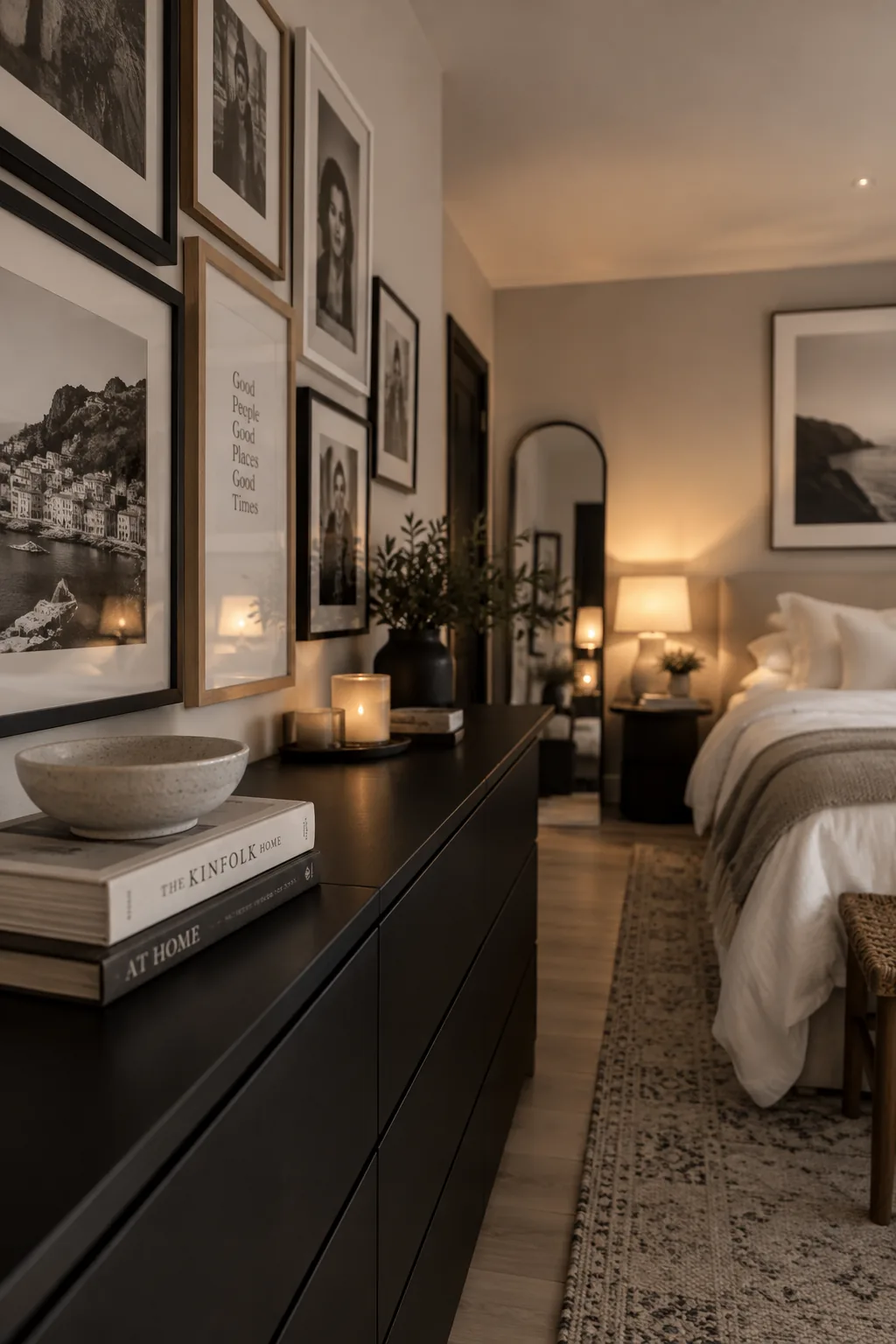 A gallery wall of black and white photos above a sleek dresser