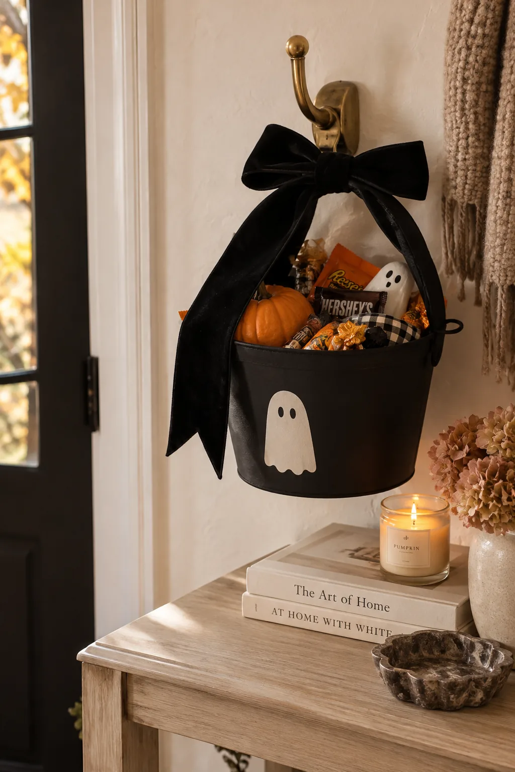 Black velvet ribbon tied around the handle of a plastic Halloween bucket.