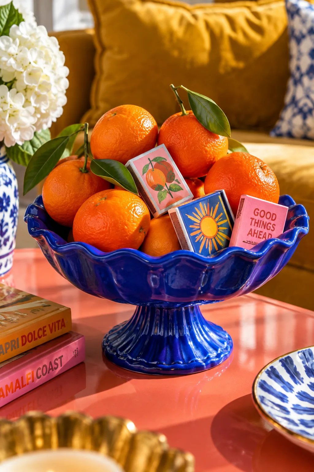A black pedestal bowl holding decorative matches on a light wood table