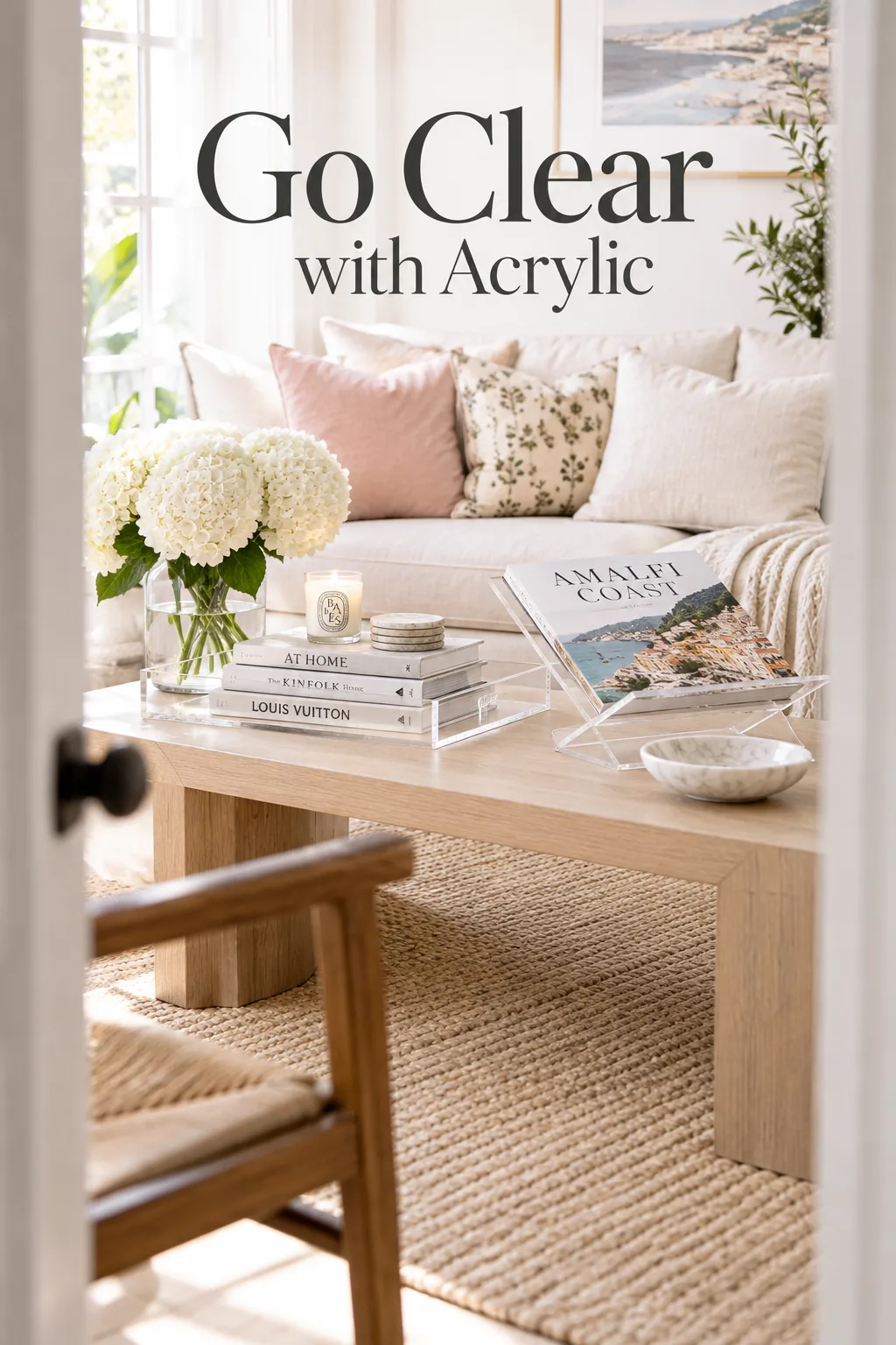A clear acrylic tray holding colorful books on a small coffee table