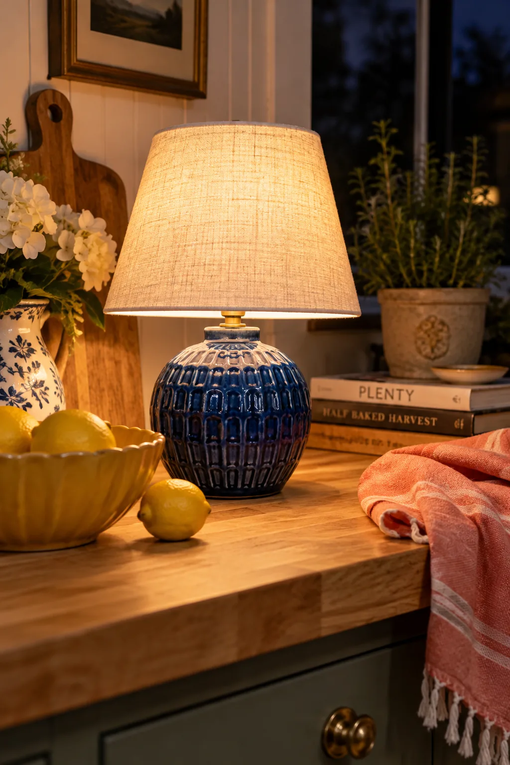 Small ceramic table lamp with a pleated shade sitting on a kitchen counter.