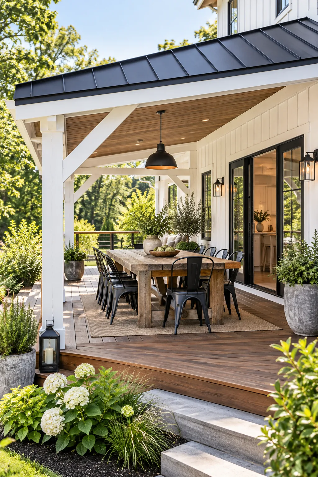 A modern farmhouse covered deck with a black metal roof and outdoor dining area.