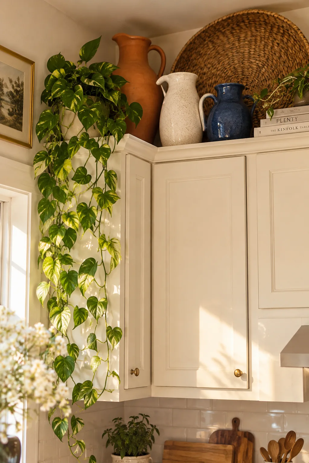 White ceramic pitchers displayed on the gap above kitchen cabinets