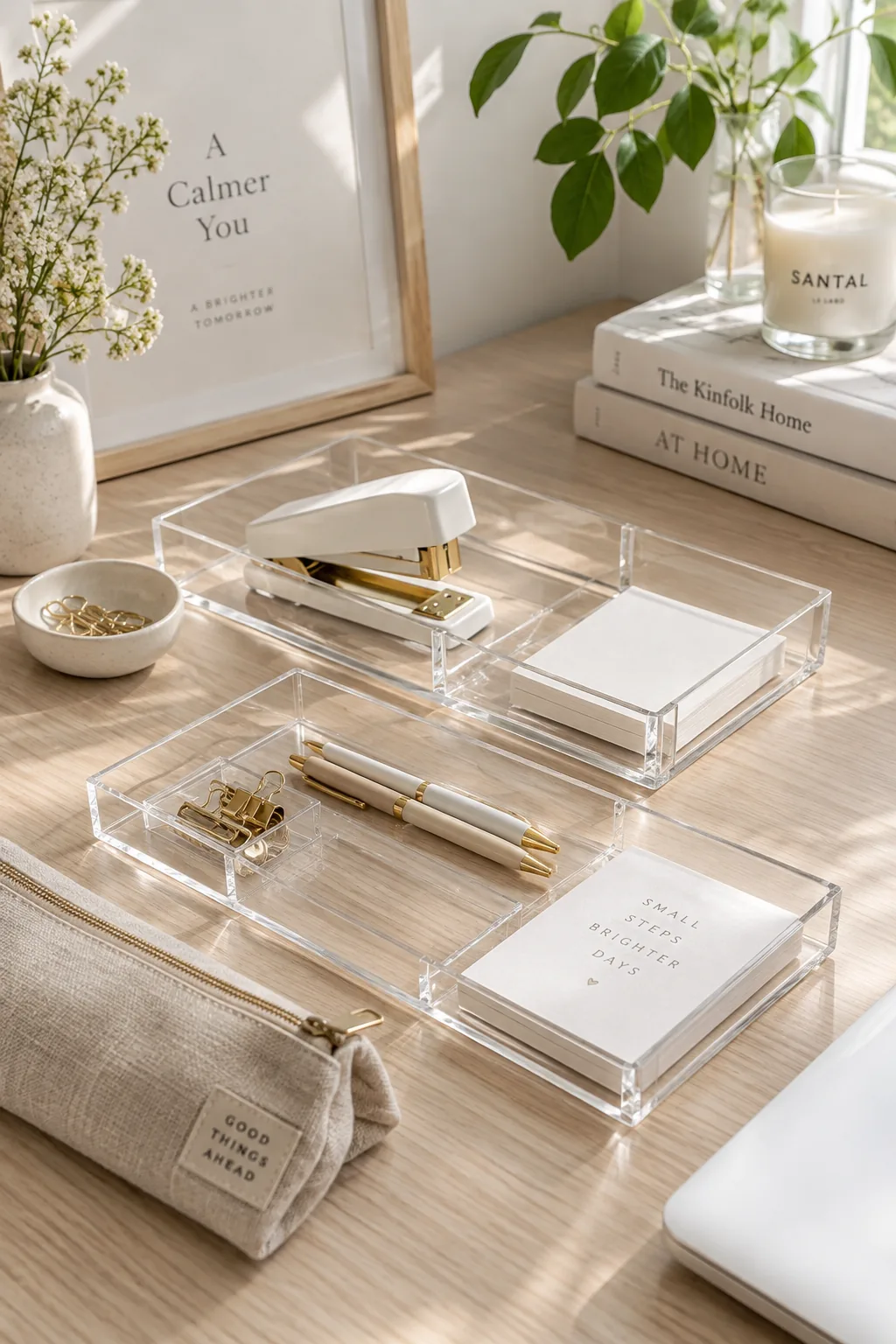 Clear acrylic tray holding sticky notes and gold paperclips