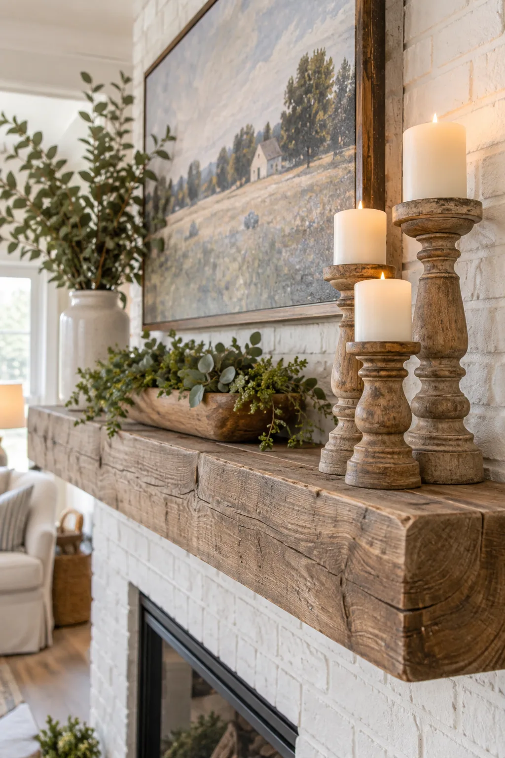 Right side of a rustic mantel featuring three chunky turned-wood candlesticks of varying heights with white pillar candles.