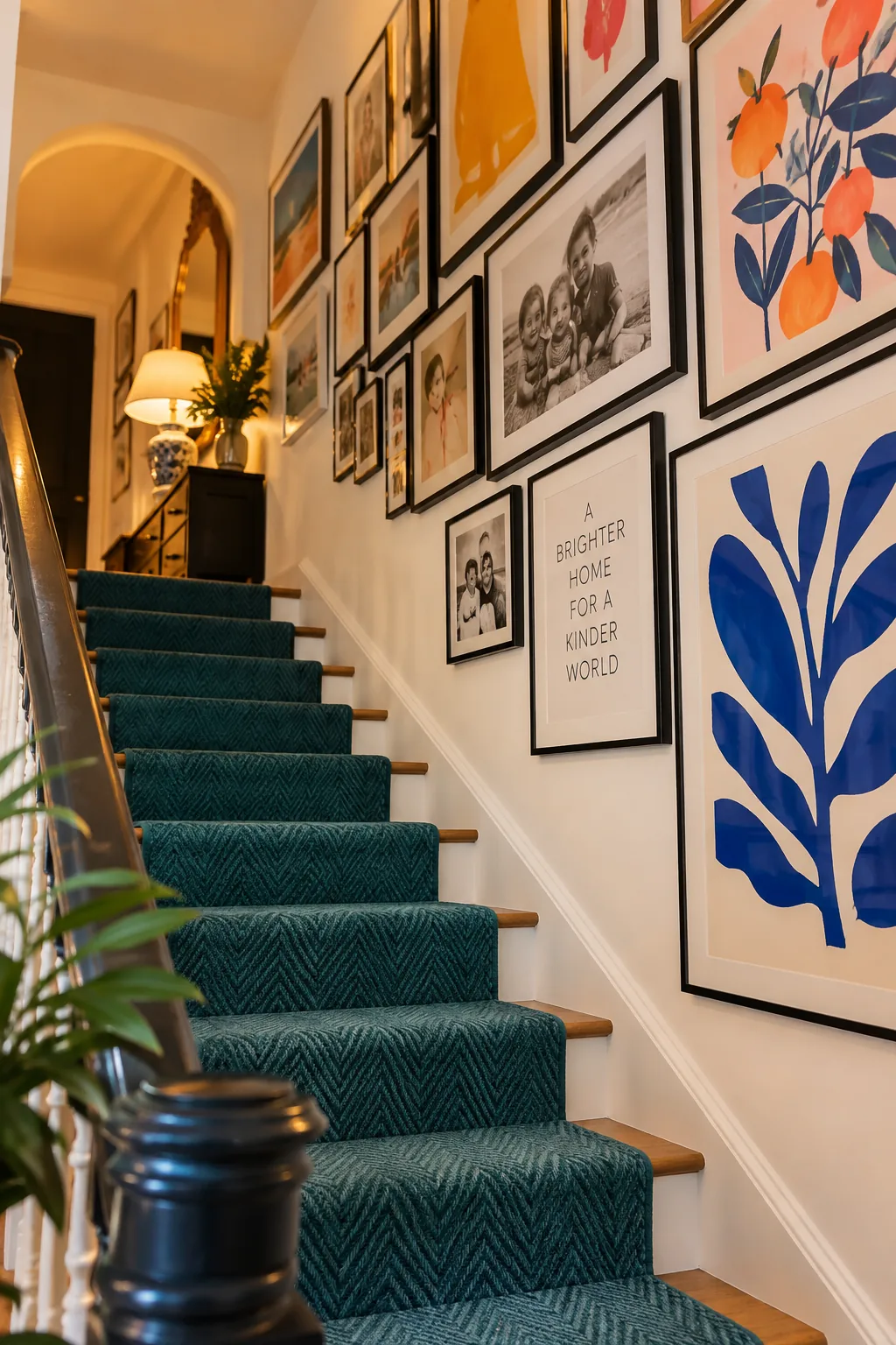 A staircase wall filled with black picture frames displaying various art and photos.