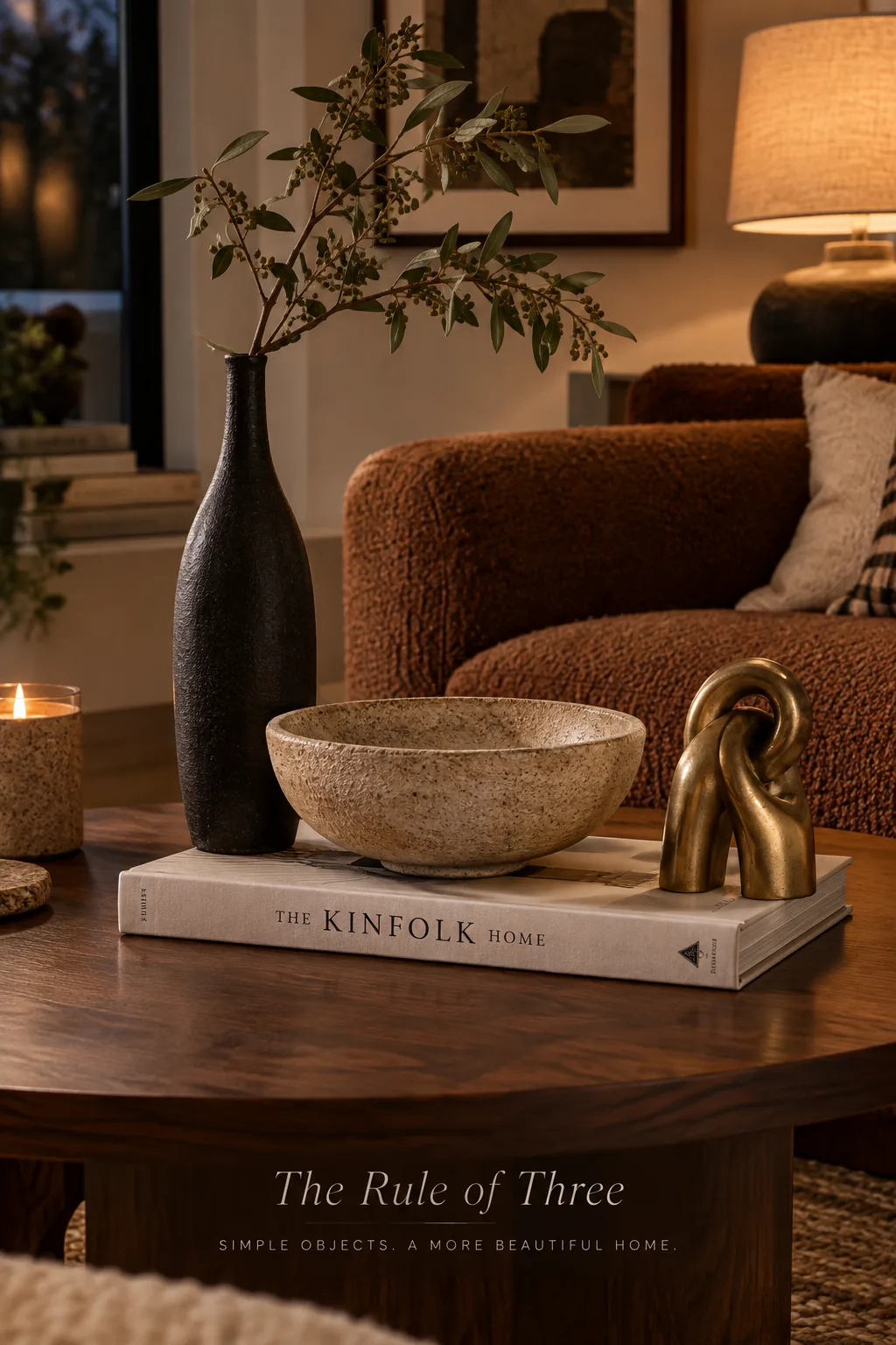 Coffee table styled with a vase, a stack of books, and a small sculpture.
