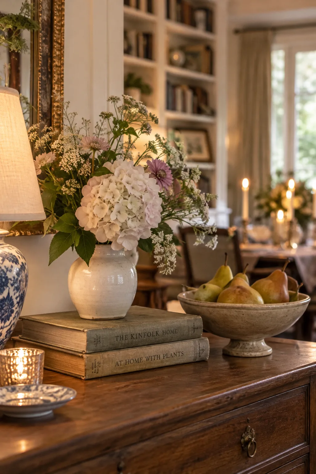 A stack of three vintage hardcover books acting as a base for a small floral vase