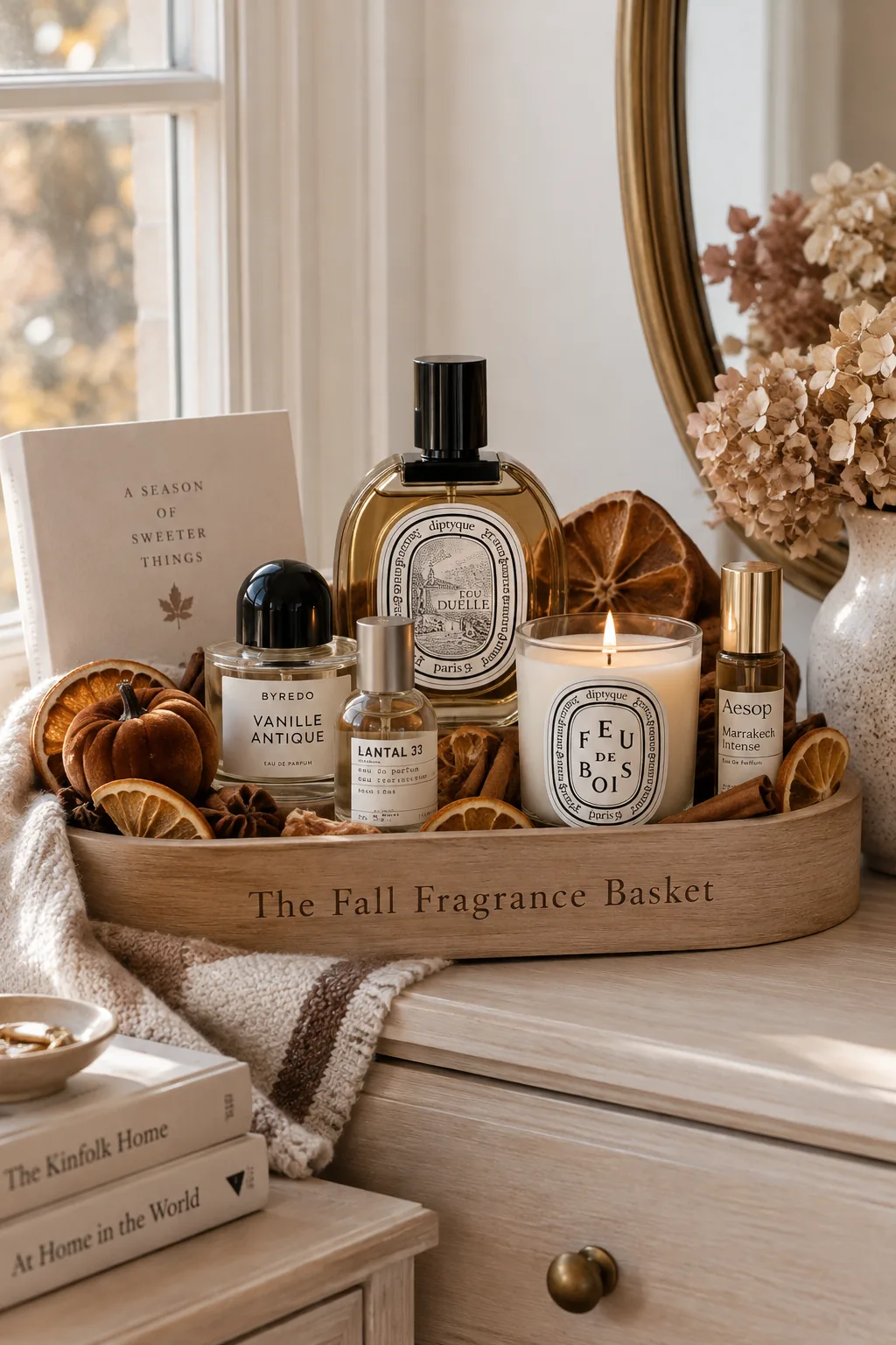 Wooden tray displaying glass room sprays, candles, and dried orange slices.