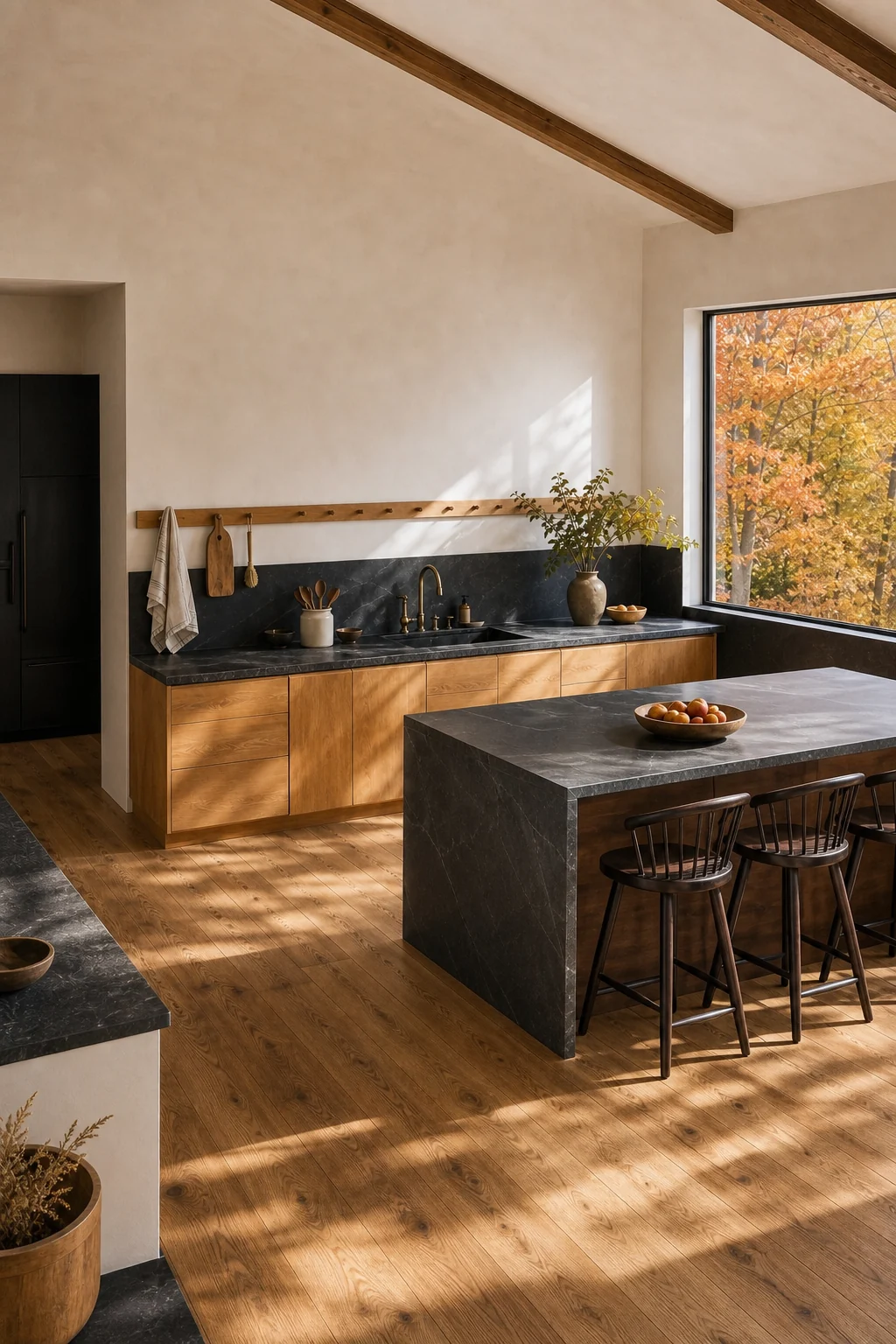 High-angle view of a kitchen showing bare plaster walls, no upper cabinets, and autumn light on maple floors.