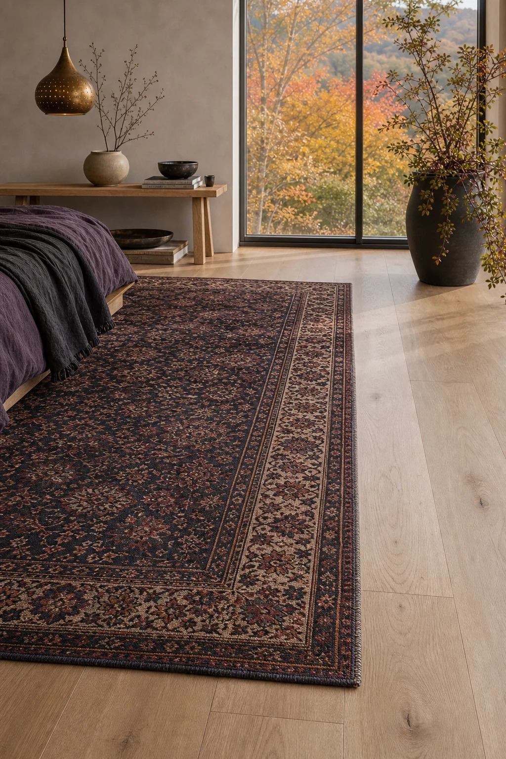 Vintage Persian rug in muted jewel tones contrasting against bare wide-plank pale oak floors.